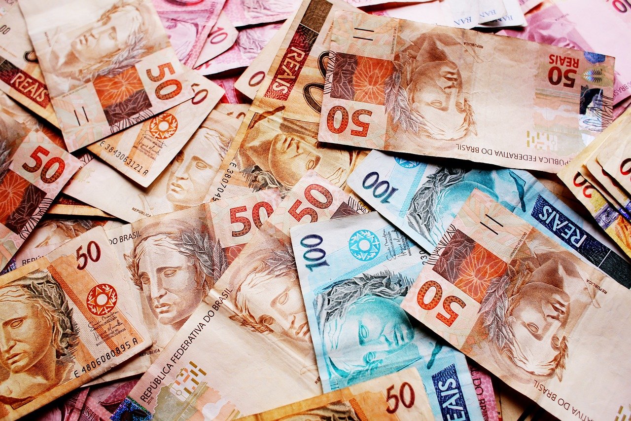 Imagem de notas de reais espalhadas para ilustrar texto sobre FIIS que distribuem dividendos
