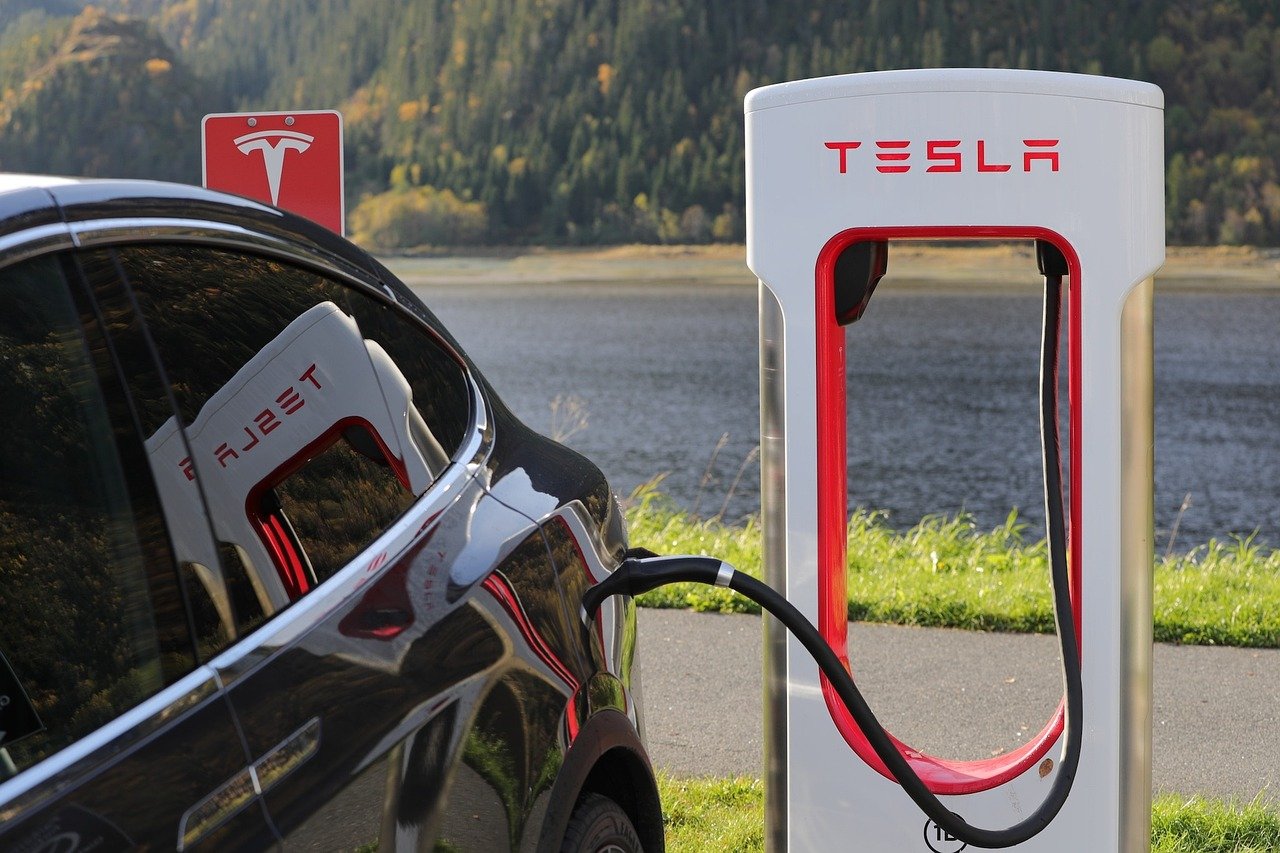 Imagem mosyra um Tesla sendo carregado.