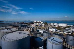 Instalações industriais da Cosan com tanques de armazenamento e vista para o mar