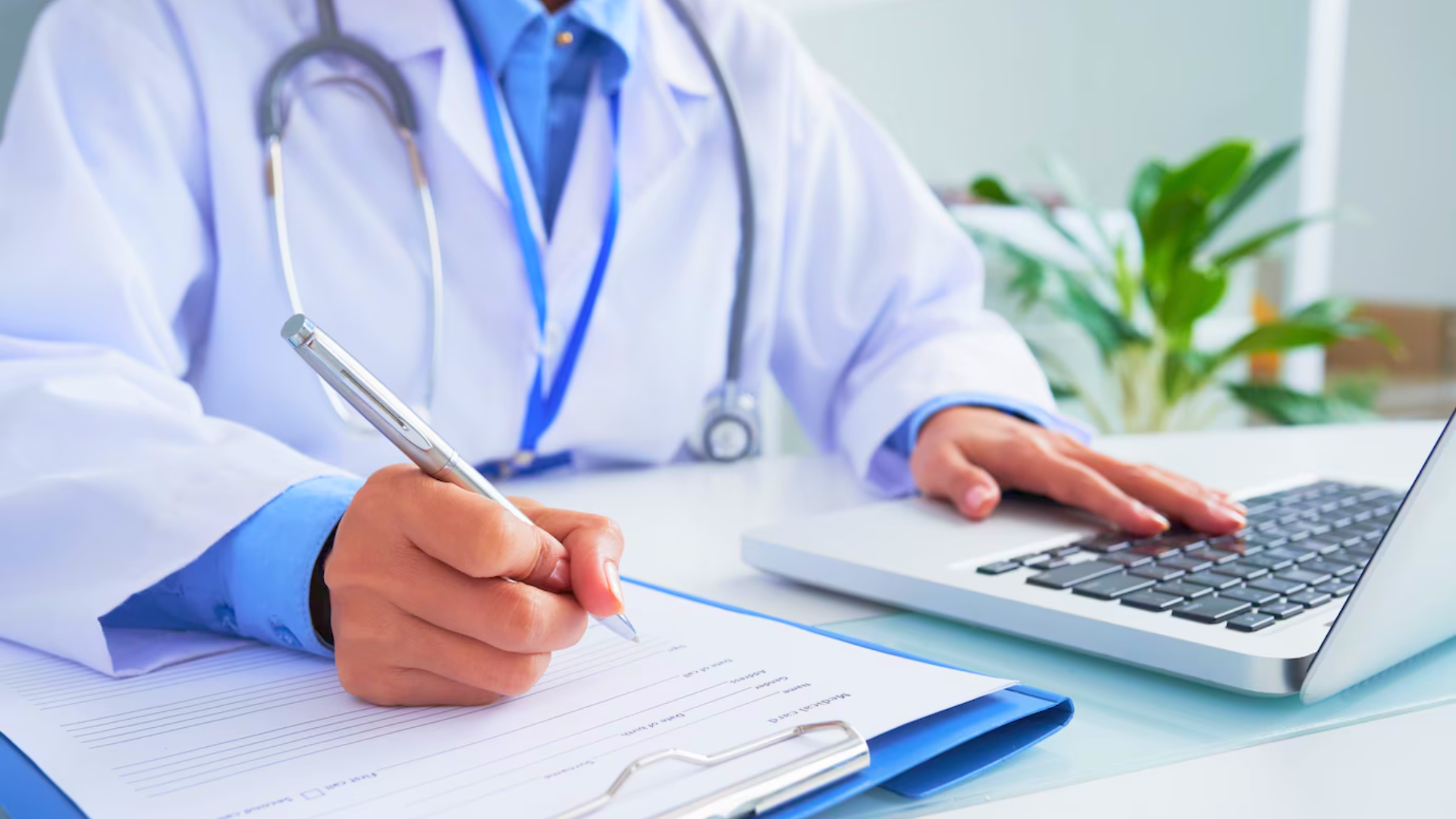 Médico fazendo anotações em um prontuário e usando um notebook