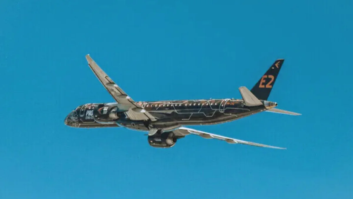 Jato E195-E2 da Embraer voando em céu azul, simbolizando os novos contratos e a expansão da empresa na África e na Europa.