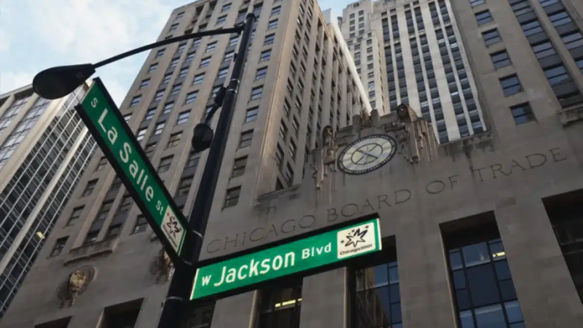 Edifício da Chicago Board of Trade (CME) com placas de rua em primeiro plano, simbolizando a suspensão das negociações eletrônicas após uma falha em seu data center.