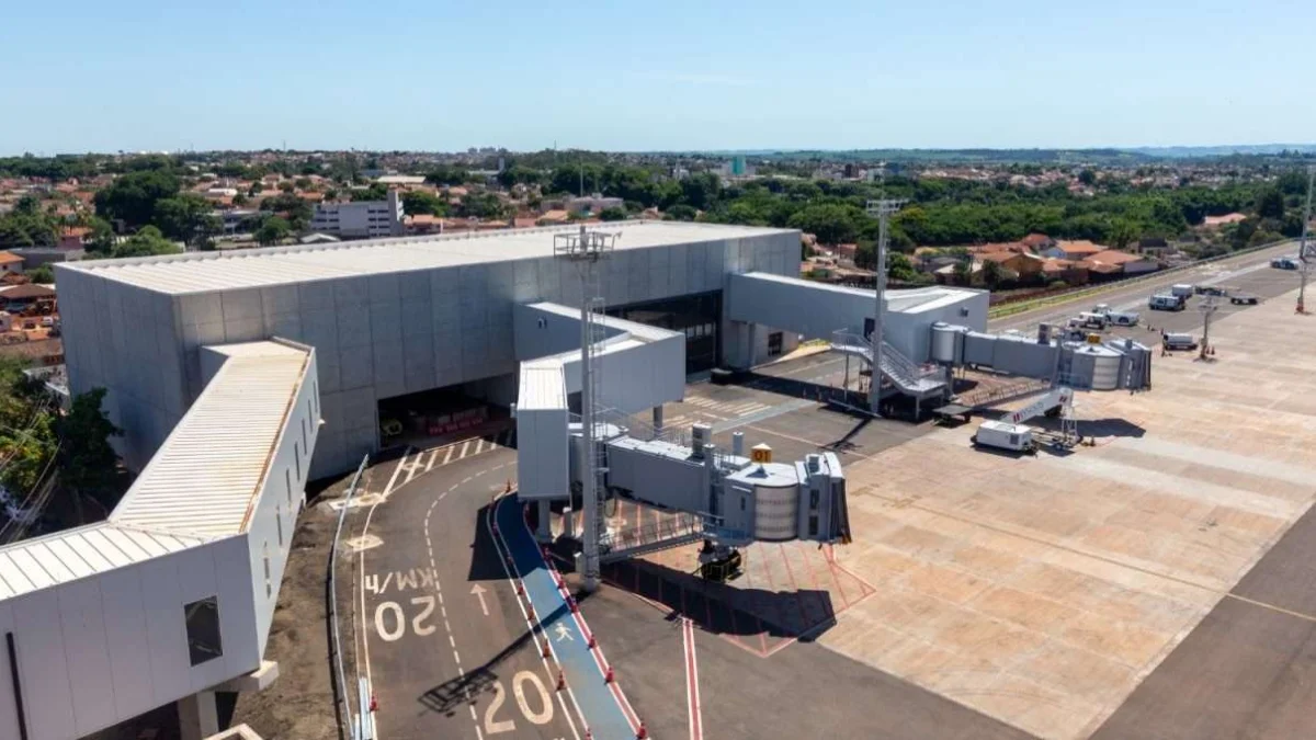 Vista aérea de um terminal de aeroporto sob sol forte, com pistas de taxiamento e pontes de embarque, simbolizando a venda da operação de aeroportos da Motiva.