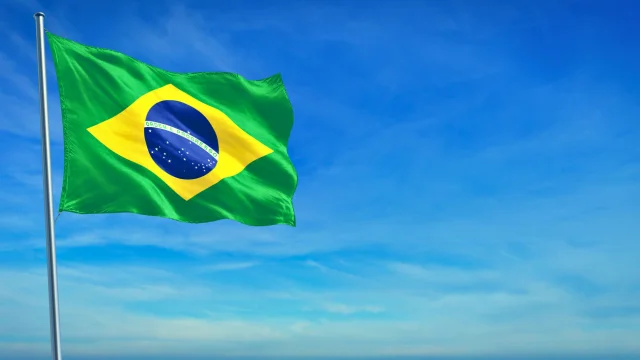 Gráfico de desempenho financeiro sobreposto à bandeira dos EUA e moedas de dólar, ilustrando a tese "Sell America" e a migração de capital global para o Ibovespa, que atingiu recordes históricos em 2026.