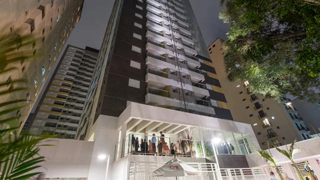 Detalhe do logotipo da Even em letras prateadas sobre uma placa cinza em uma fachada de vidro, representando a incorporadora para a análise da even xp.