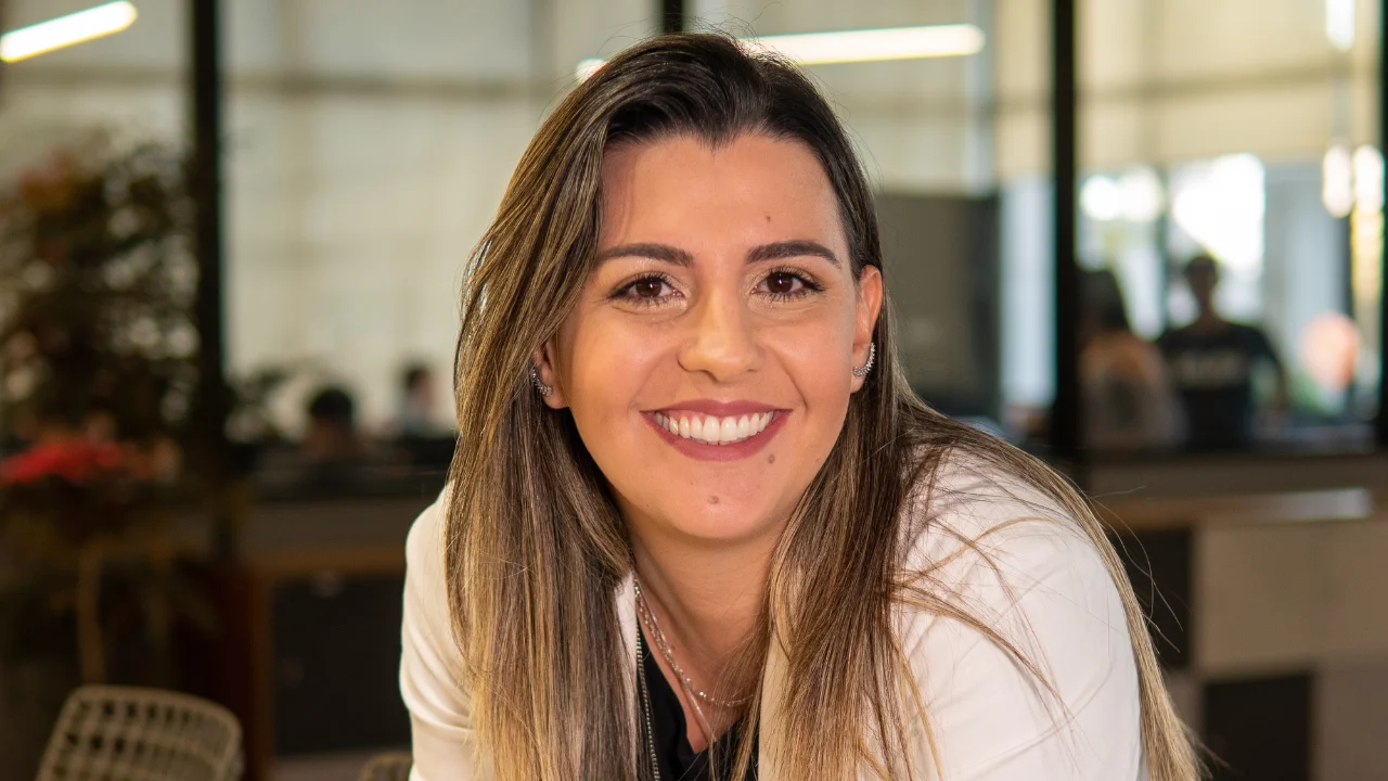 Ariane Scacalossi, educadora financeira do Klubi, sorri durante entrevista sobre educação financeira e finanças pessoais.
