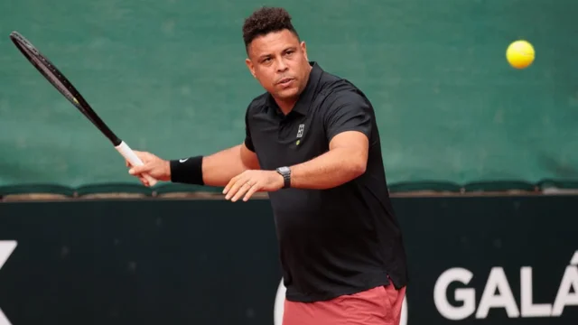 Ronaldo Nazário, o Fenômeno, jogando tênis em uma quadra, simbolizando a notícia de que o ex-jogador trocou o futebol pelos investimentos no esporte.