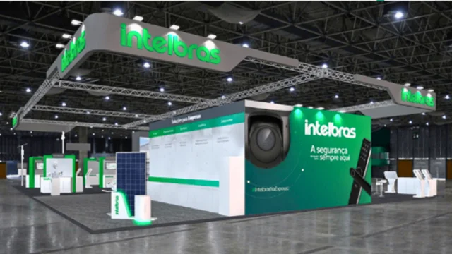 Estande de grandes dimensões da Intelbras em uma feira de eventos, exibindo painéis com câmeras de segurança, fechaduras digitais e placas de energia solar, representando a Intelbras receita.