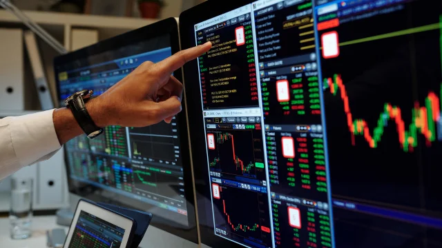 Homem olhando e apontando bolsa de valores