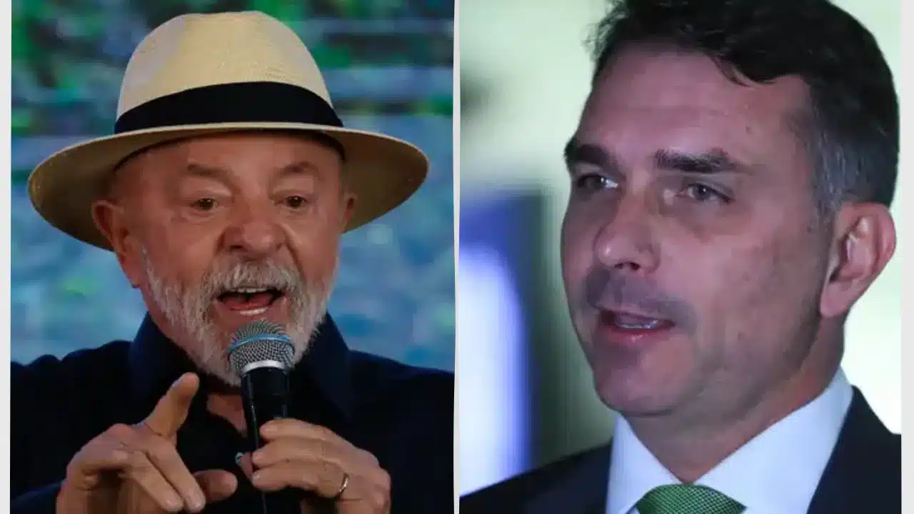 Montagem fotográfica dividida verticalmente ao meio com retratos em primeiro plano de duas lideranças políticas brasileiras. Do lado esquerdo, o presidente Luiz Inácio Lula da Silva fala de boca aberta em um microfone preto com detalhe prateado, usando um chapéu panamá de palha clara com faixa preta e camisa escura; ele aponta o dedo indicador direito para a frente. Do lado direito, o senador Flávio Bolsonaro é retratado em meio-perfil olhando ligeiramente para a esquerda, exibindo uma expressão séria, vestindo paletó cinza-escuro, camisa social branca e gravata verde. O fundo de ambas as imagens apresenta iluminação de estúdio levemente desfocada.