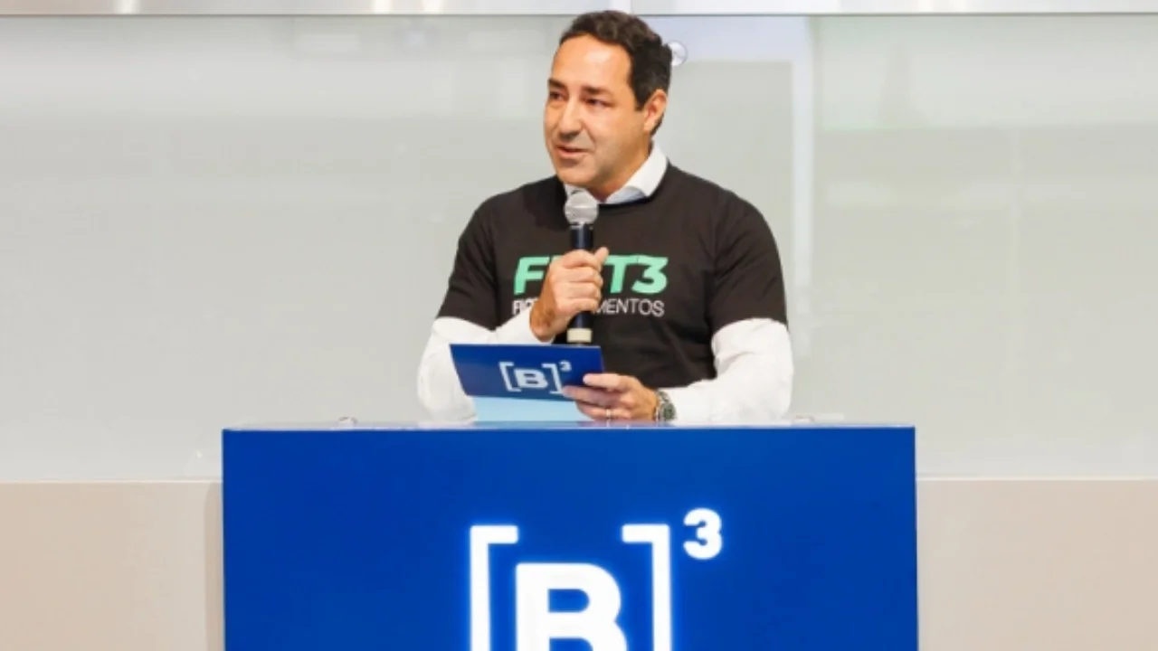 Executivo discursando no púlpito com logotipo da B3 vestindo camiseta com a marca FICT3 Fictor Alimentos.