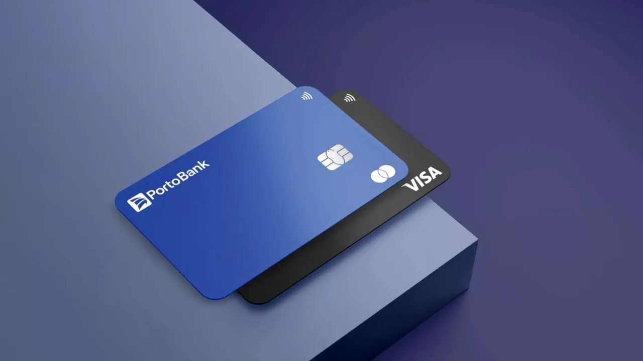 Cartões de crédito do Porto Bank em destaque sobre superfície geométrica azul e preta.