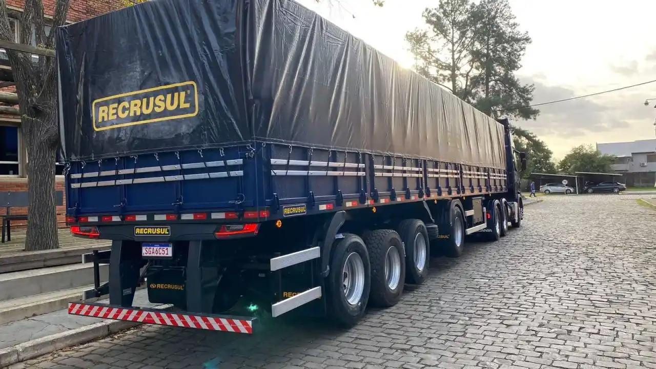 Implemento rodoviário azul fabricado pela Recrusul estacionado em área externa.
