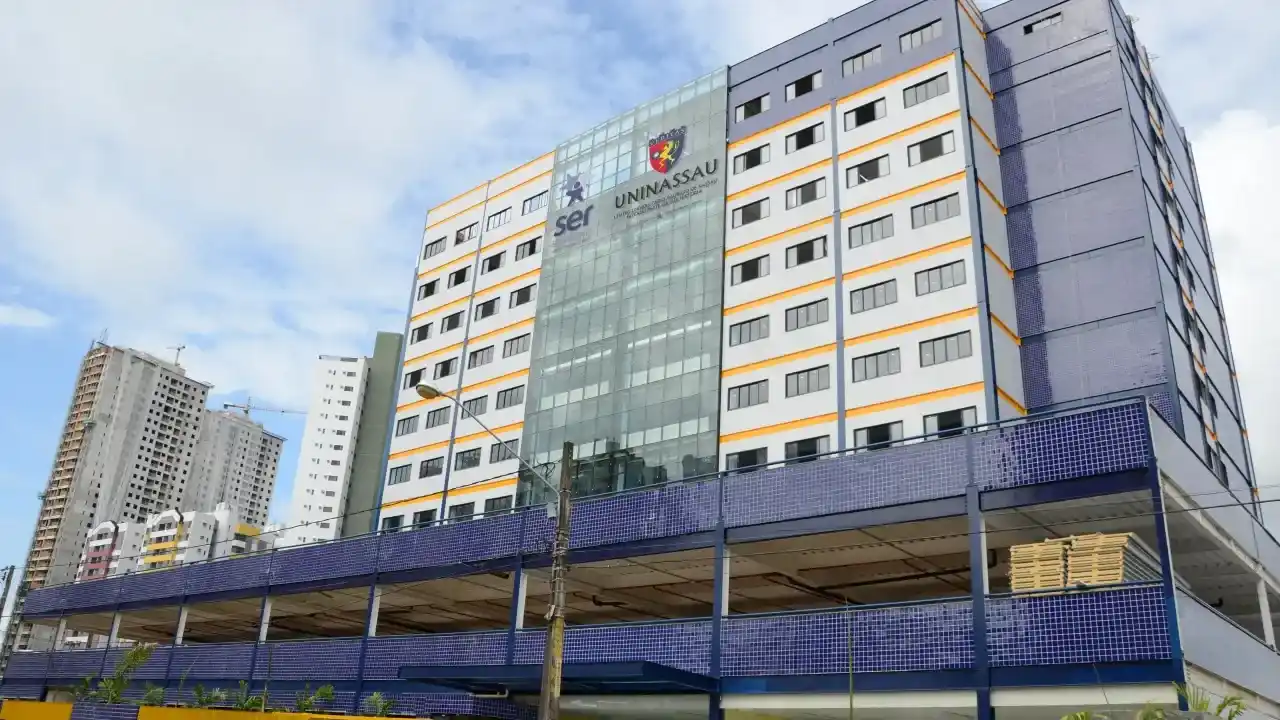 Fachada do prédio do campus Uninassau, do grupo Ser Educacional, sob céu ensolarado.
