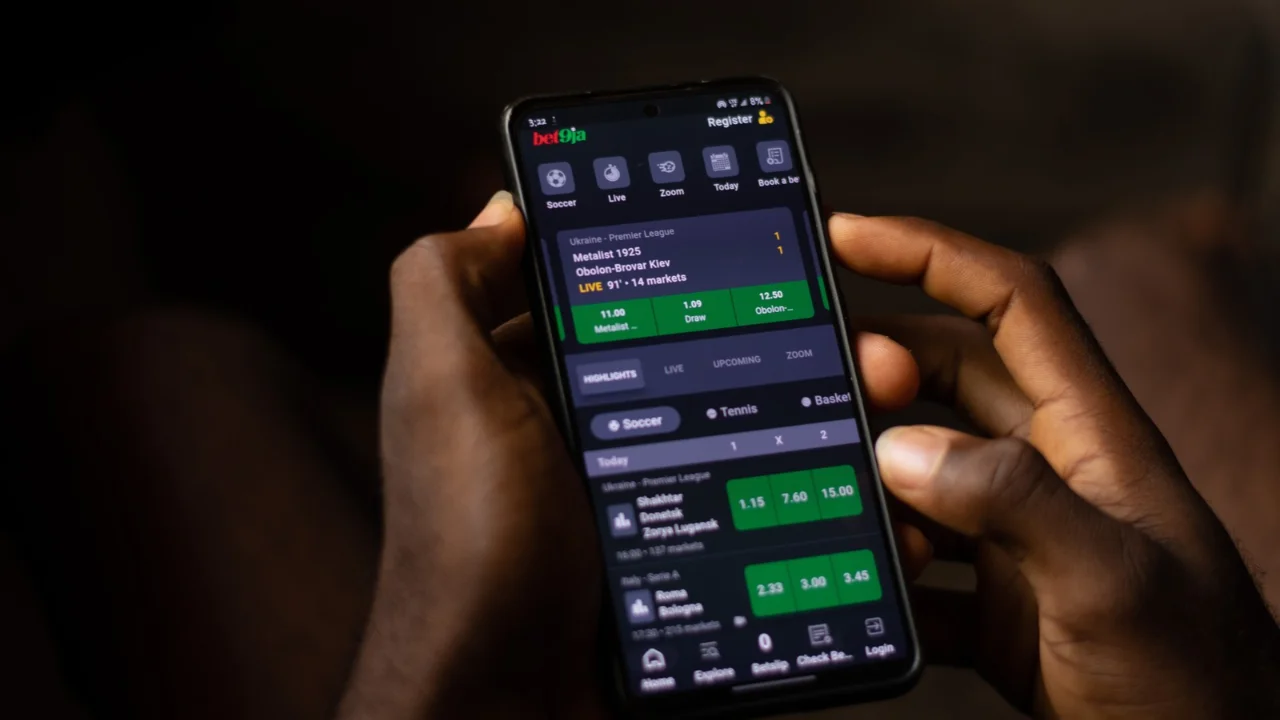 Pessoa utiliza aplicativo de apostas no smartphone em matéria sobre a devolução de R$ 1,3 bilhão aos apostadores das bets.