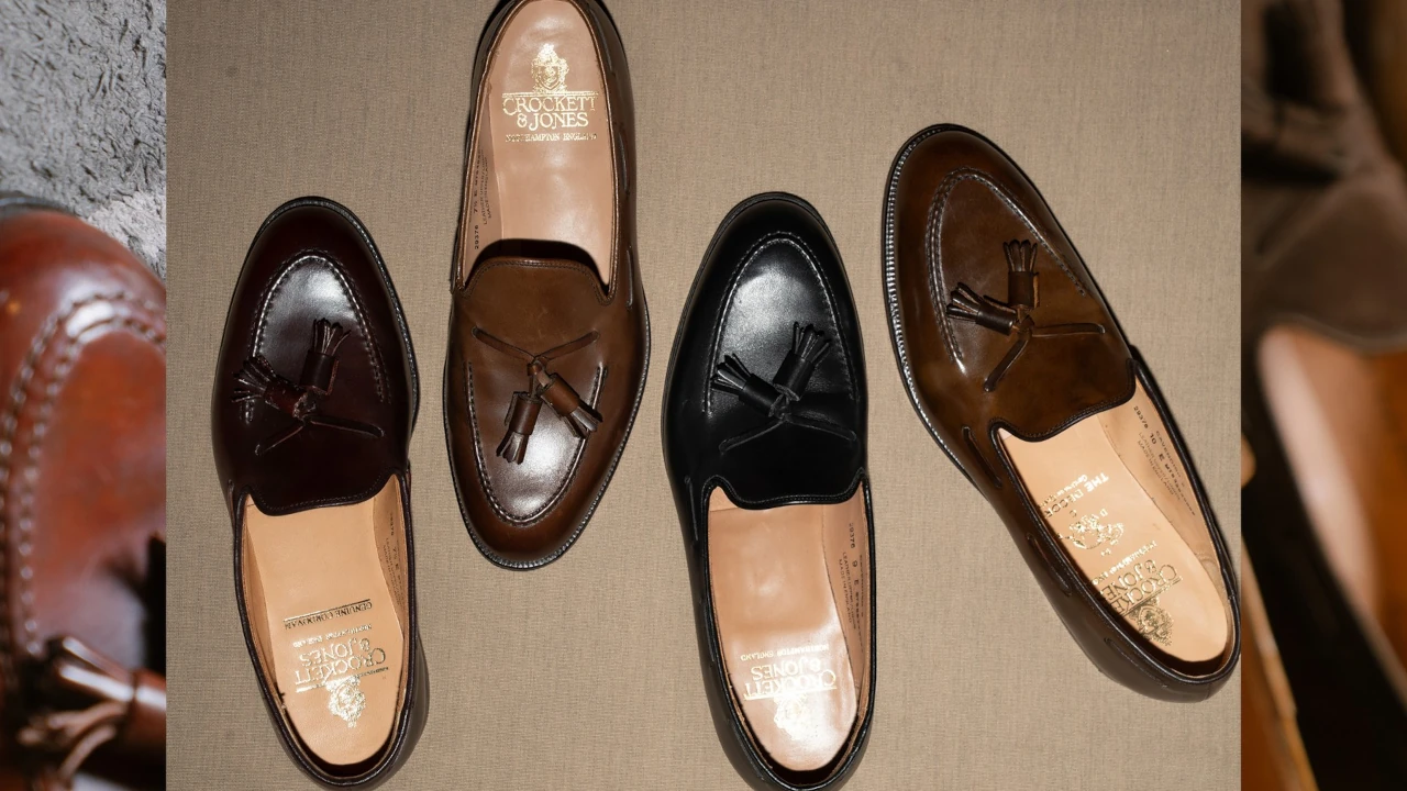 Quatro pares de loafers com tassel da Crockett & Jones, em tons de marrom e preto, dispostos lado a lado sobre uma superfície bege. Os sapatos apresentam acabamento em couro polido e detalhes artesanais no cabedal