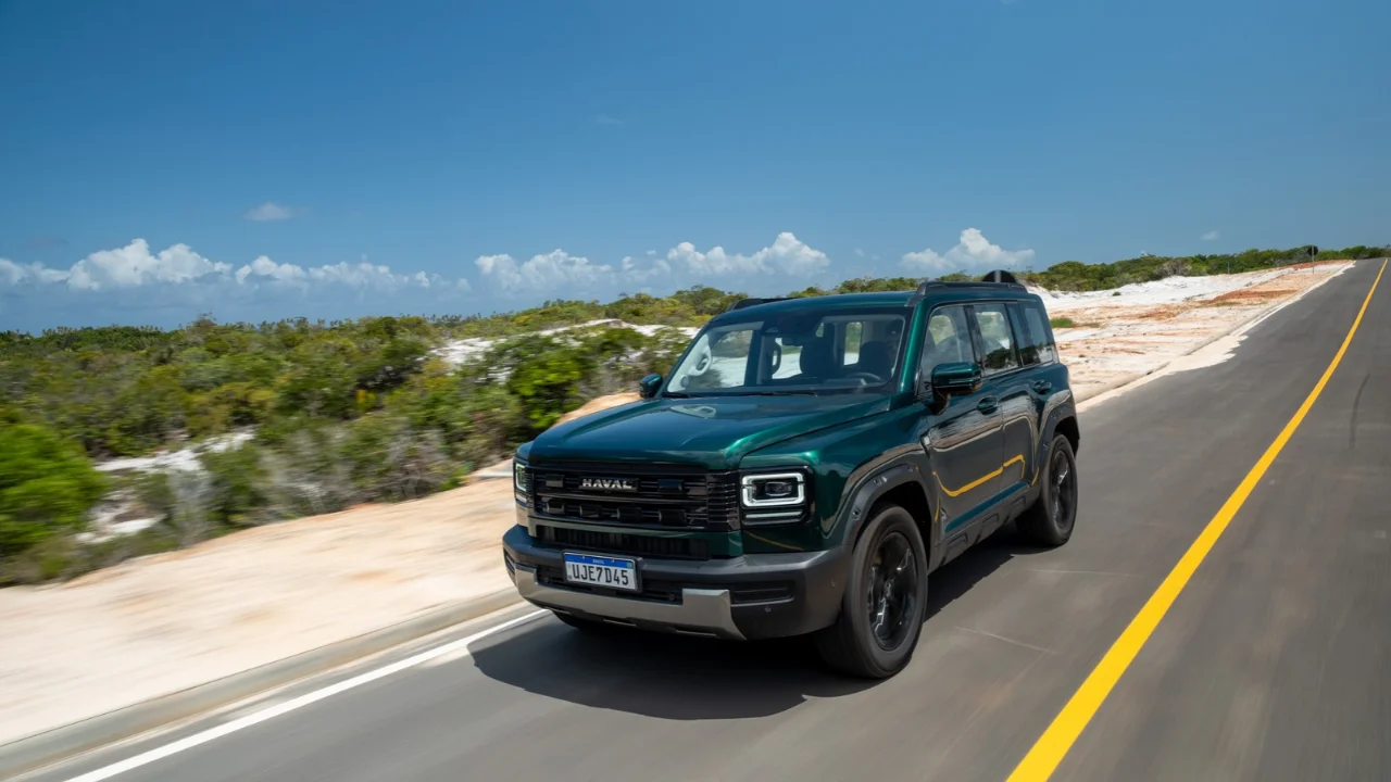 SUV híbrido plug-in Haval H7 em cor verde escuro rodando em estrada em matéria sobre lançamento de R$ 261 mil com isenção de IPVA.