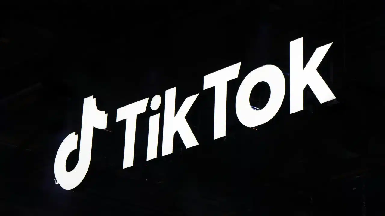 Logotipo do TikTok em destaque sobre fundo escuro, representando a plataforma e seus serviços de conteúdo e comércio digital