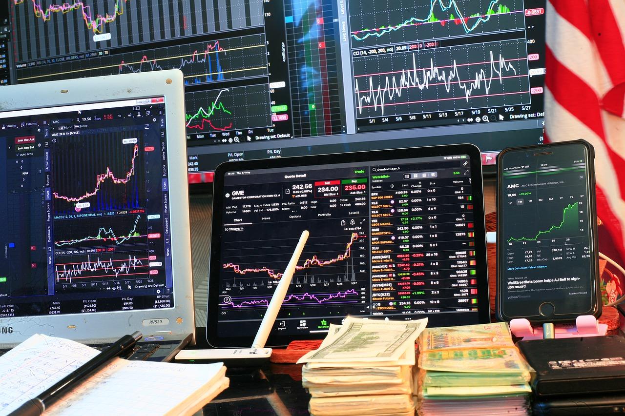 Imagem mostra telas em ações, com investidor atento aos ativos.