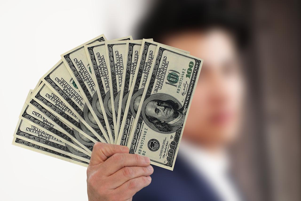 foto de homem exibindo notas de dólares
