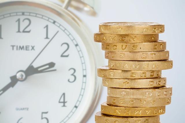 foto de relógio e moedas empilhadas: risco de reinvestimento