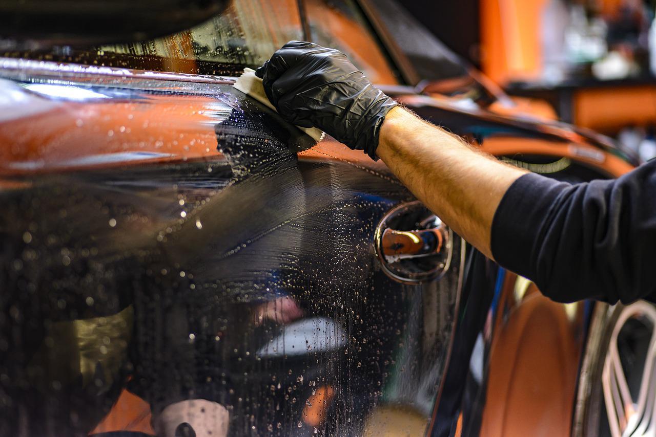 Imagem mostra um profissional de higienização de carro trabalhando.