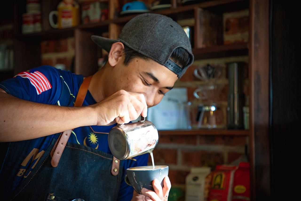 Imagem mostra um barista fazendo um café.