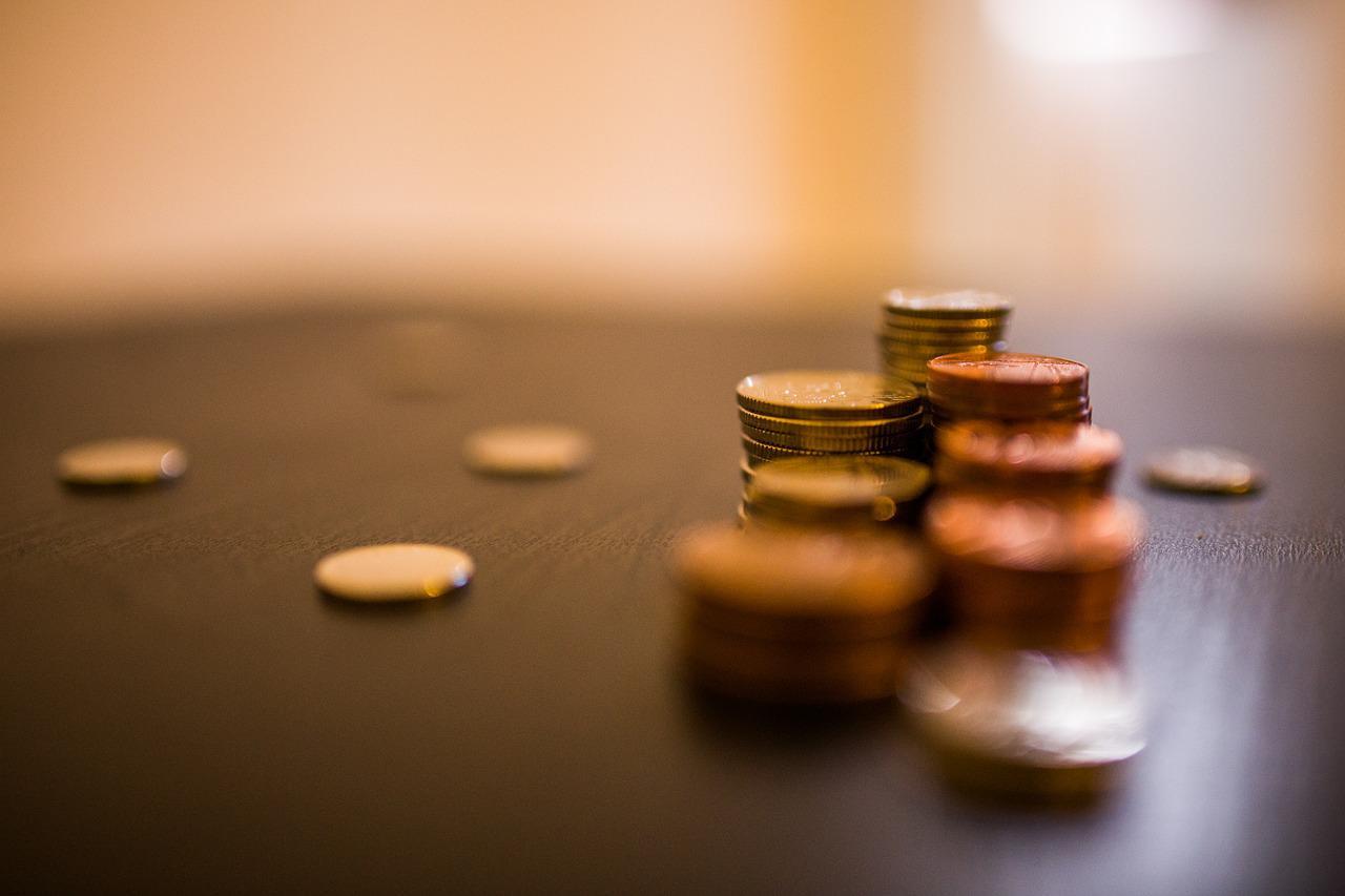 Imagem mostra um tanto de moedas sobre a mesa.