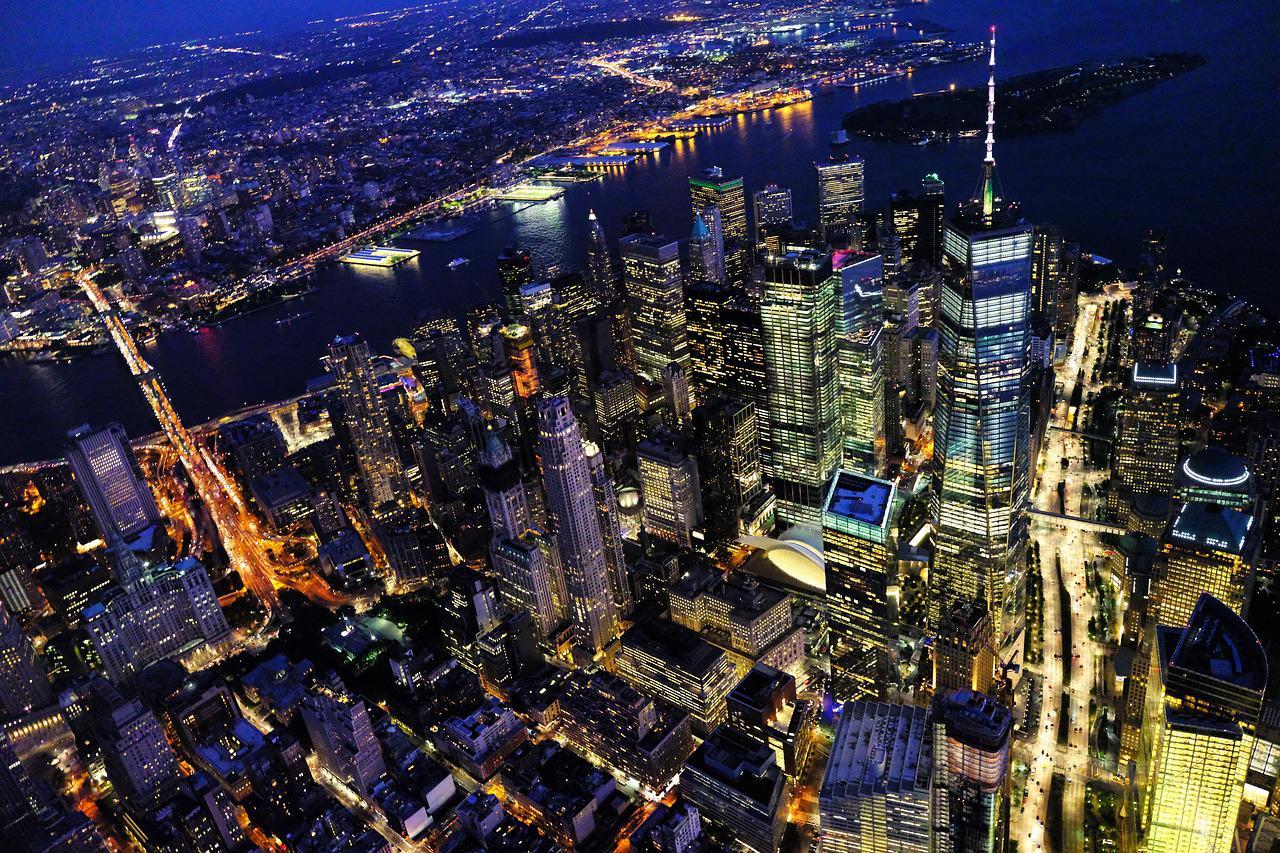 Imagem mostra prédios iluminados à noite em Nova York. EUA. A confiança do consumidor no país está em alta moderada.