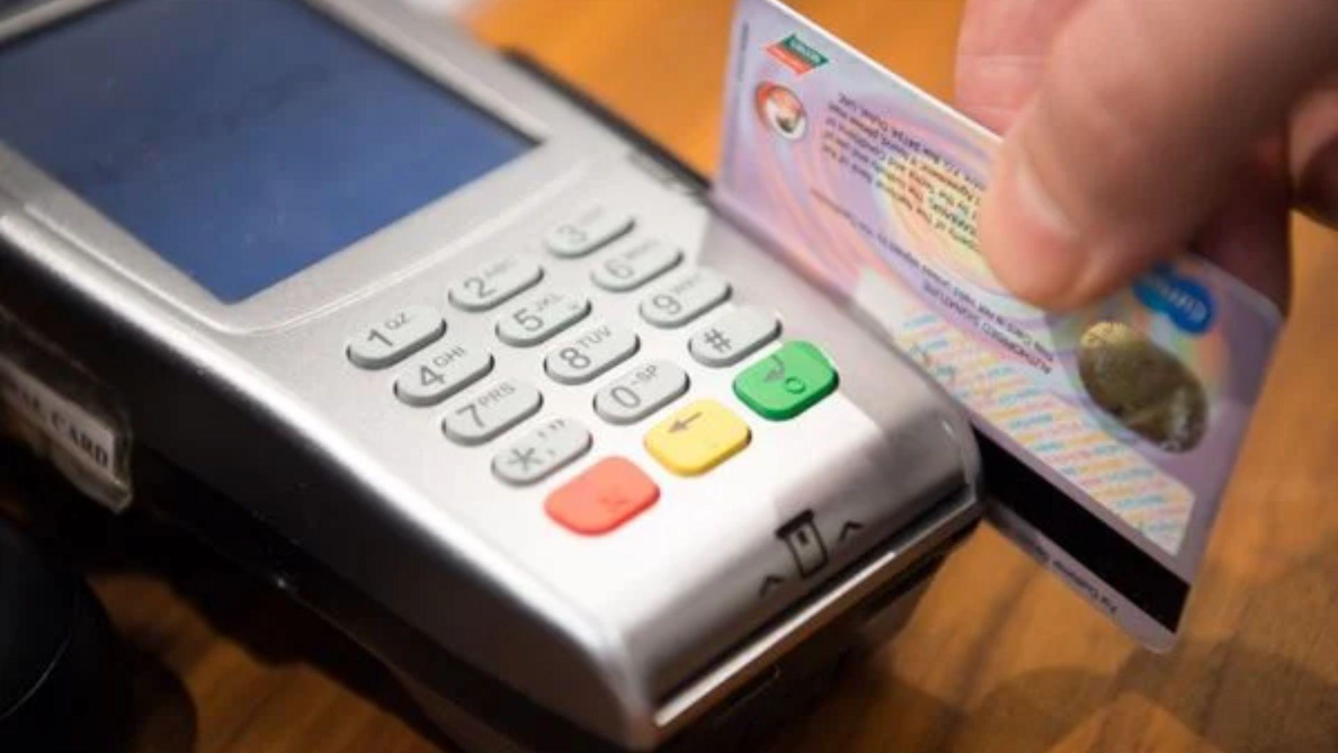 Pessoa passando cartão de crédito na máquina