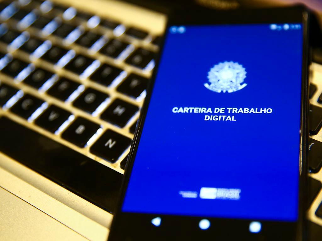Imagem mostra celular com tela do aplicativo Carteira de trabalho digital. Matéria apresenta dados do Caged de março de 2023