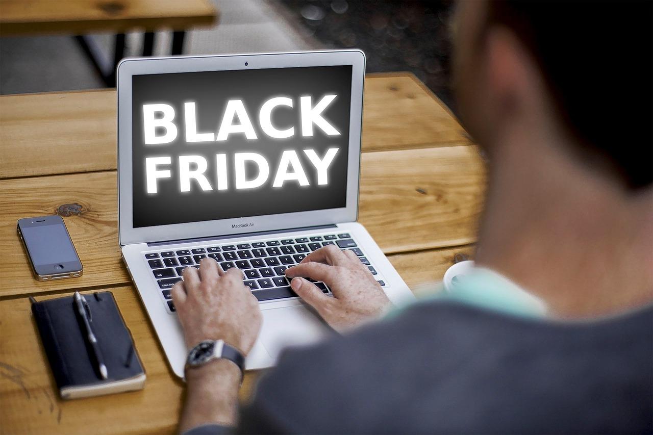 Imagem mostra pessoa usando laptop com a inscrição "Black Friday" na tela