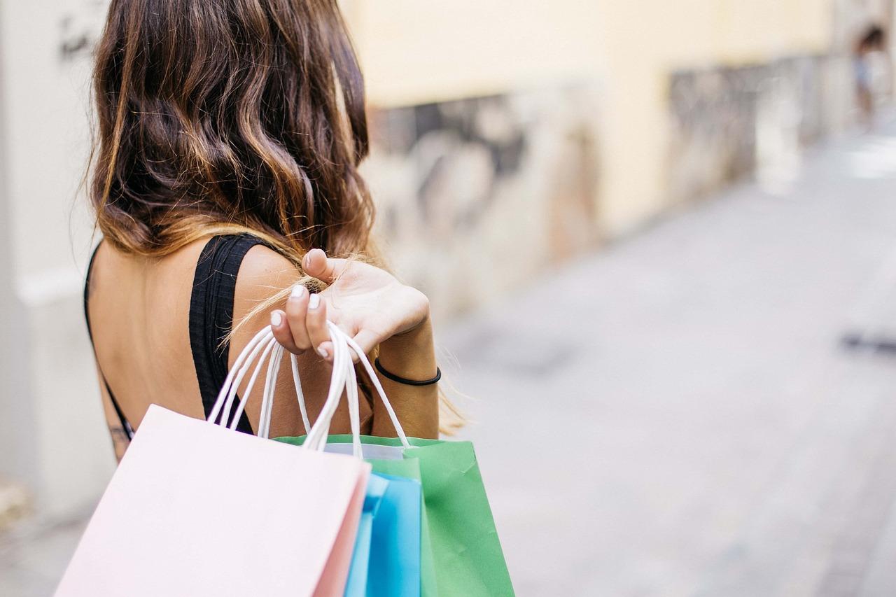 Imagem mostra mulher com compras em shopping, para ilustrar matéria sobre a confiança do consumidor dos EUA em novembro, que apresentou queda
