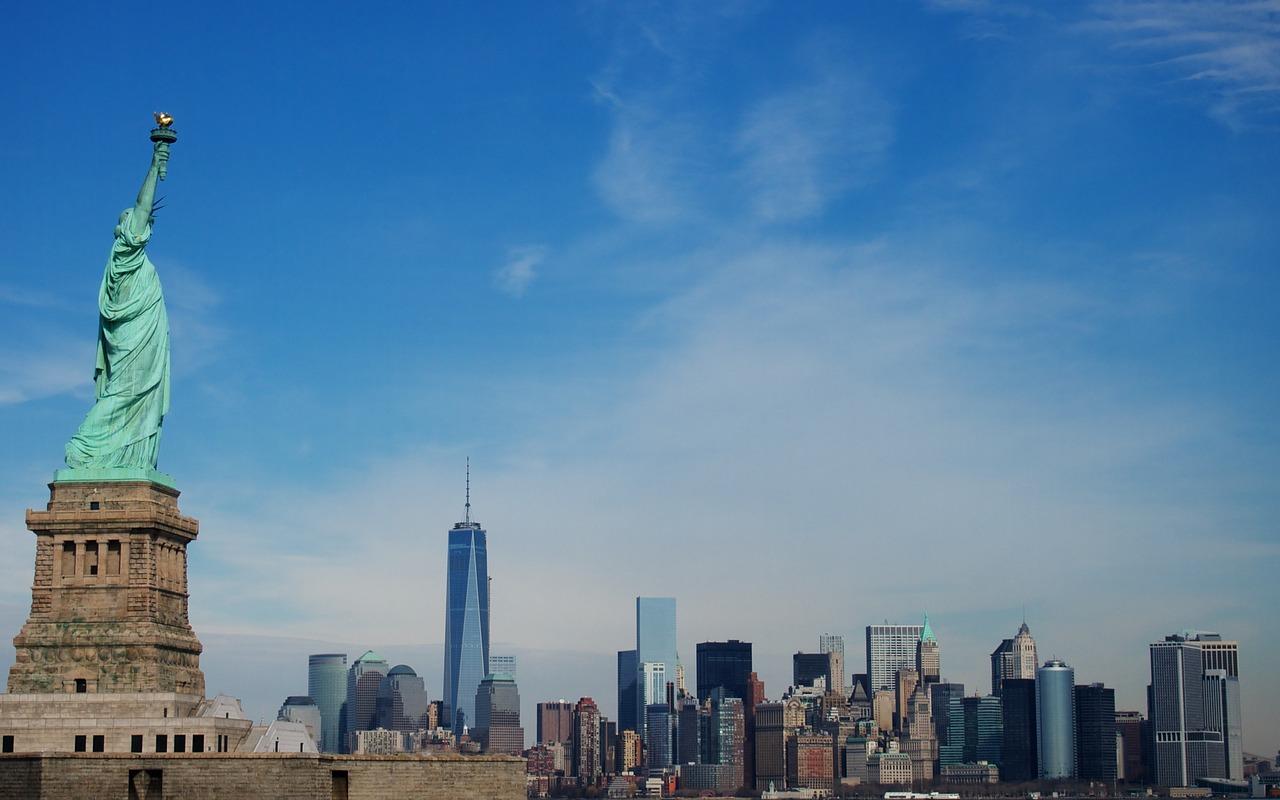 Imagem mostra skyline diurno do Nova York, com a estátua da liberdade em primeiro plano, para ilustrar matéria sobre PIB dos EUA