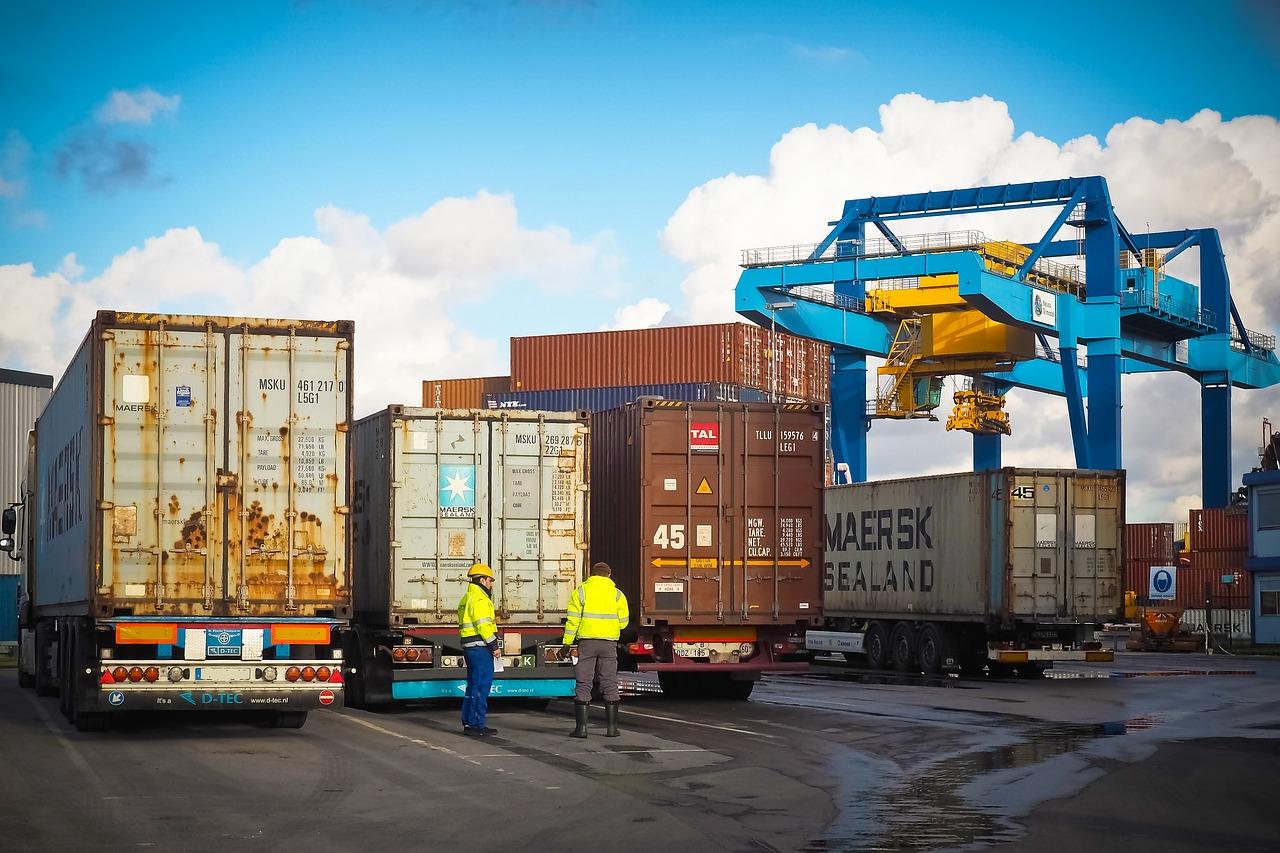 Imagem mostra contêineres dentro de caminhões em um porto