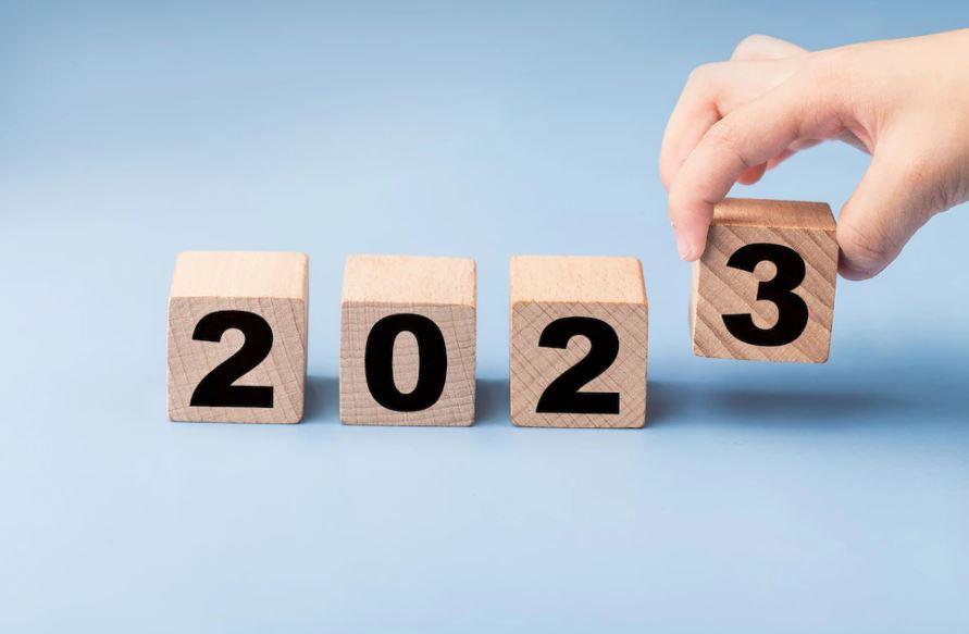 foto de mão girando cubos de madeira onde se lê 2023: onde investir em 2023?