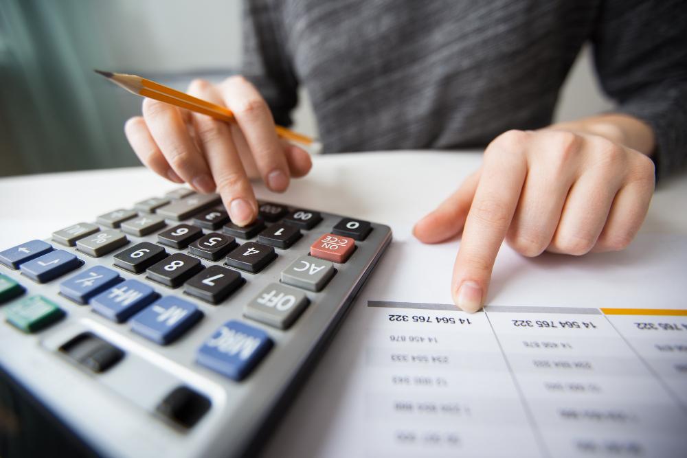 Homem usa calculadora em foto para ilustrar matéria sobre empréstimo consignado