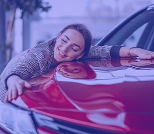 consórcio x financiamento: foto de garota abraçando carro