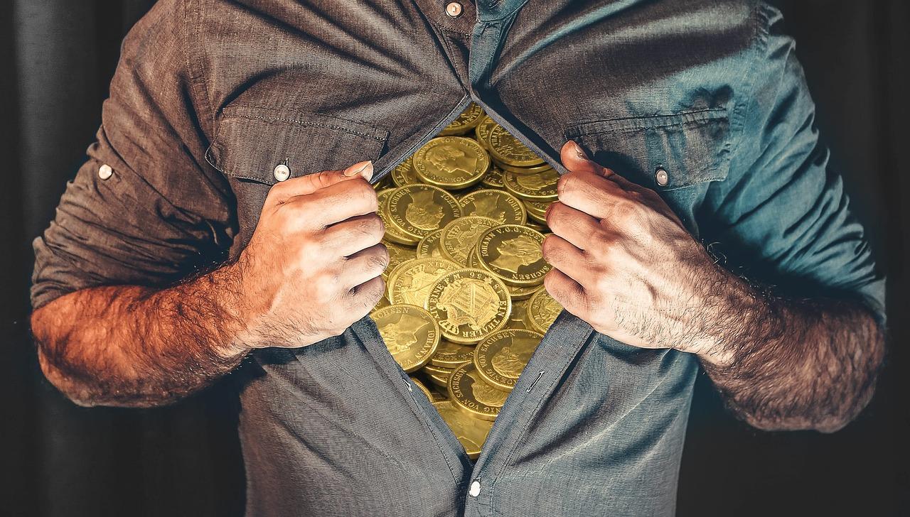 Imagem mostra um homem abrindo a camisa e tendo moedas no peito.