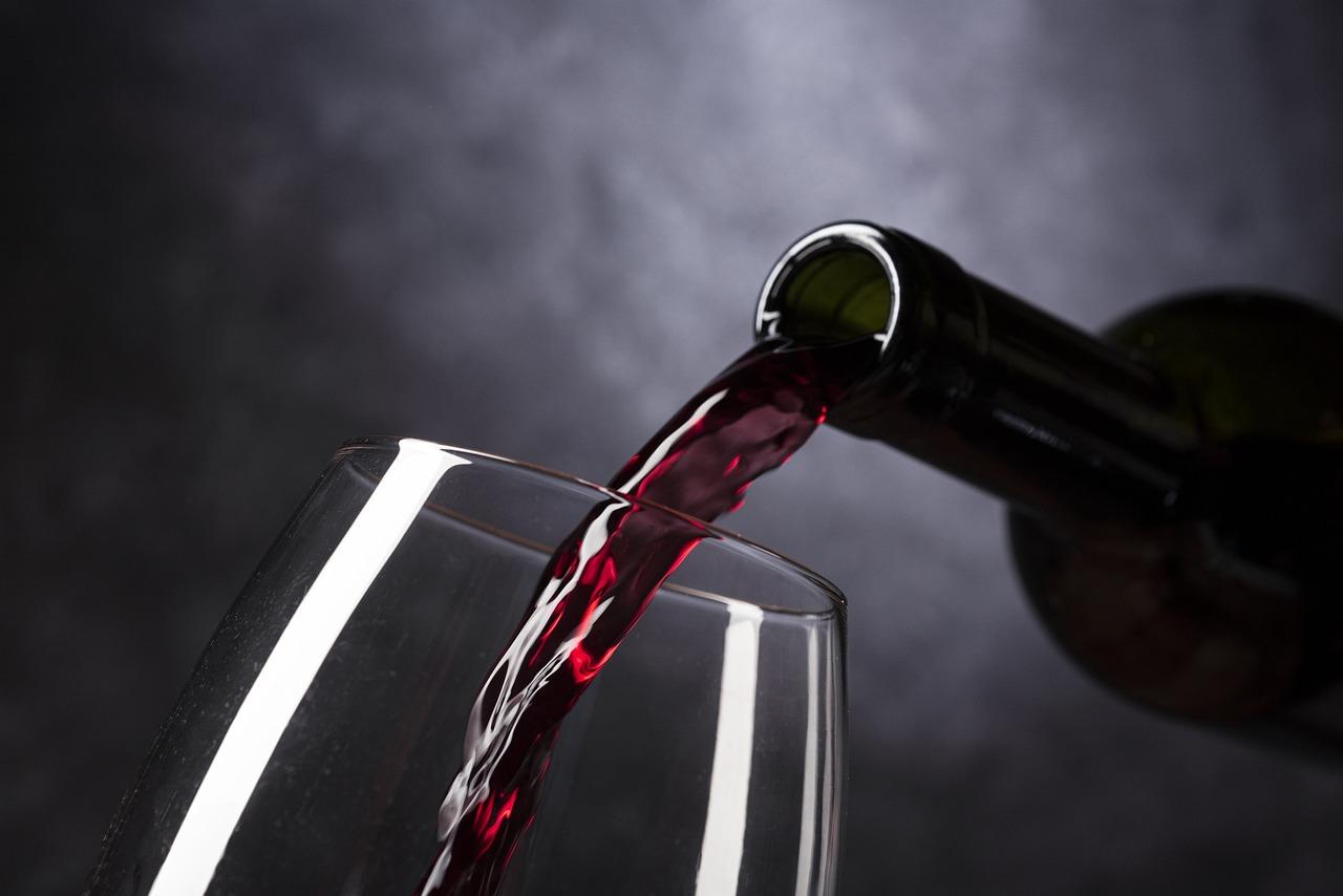 Imagem mostra uma garrafa de vinho e um copo.