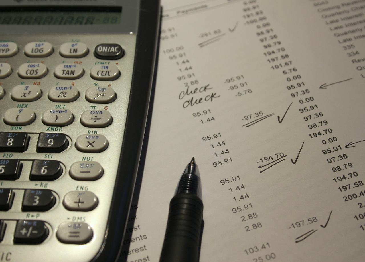 Imagem de calculadora próxima a papéis com números e caneta para ilustrar matéria da reforma tributária sobre investimentos