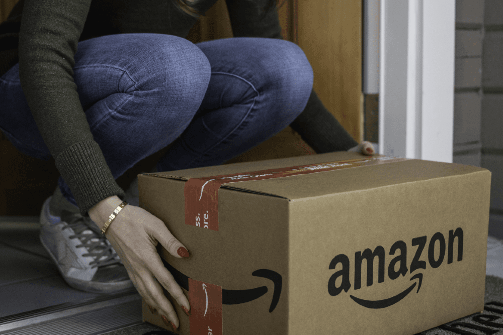 Foto de mulher pegando caixa da Amazon para matéria sobre balanço da empresa