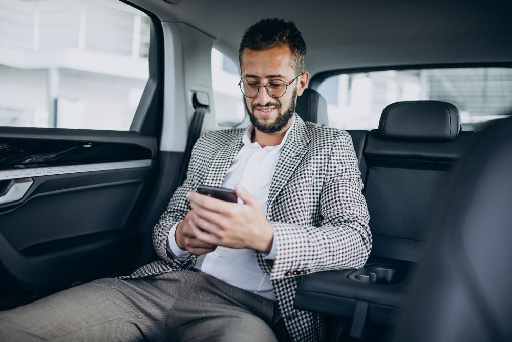 Passageiro no carro mexendo no celular para ilustrar parceria entre Nubank e Uber