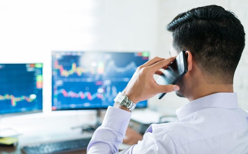 foto de homem ao telefone negociando ações: insider trading