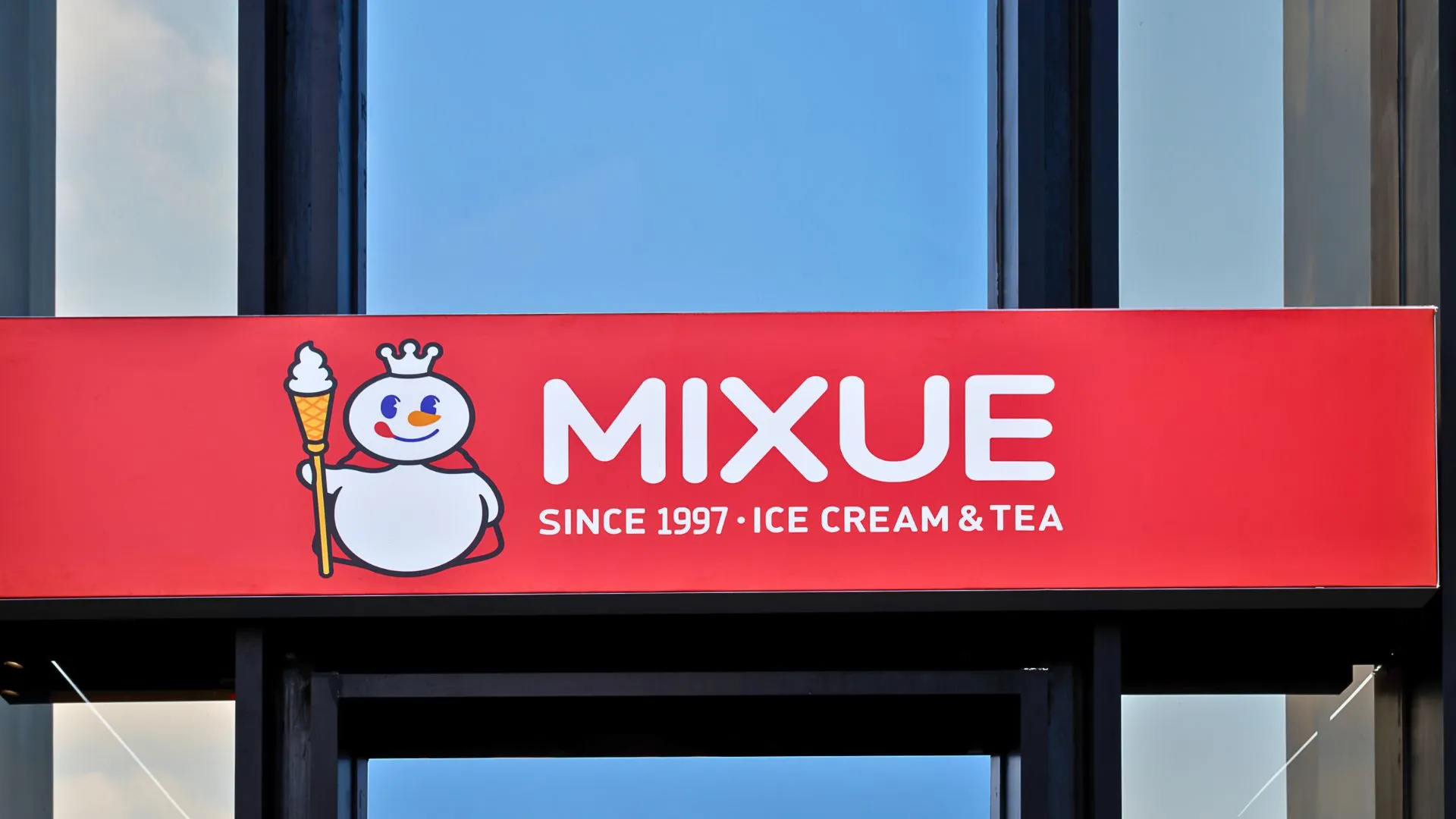 Fachada da loja Mixue com letreiro vermelho e logo da marca em destaque