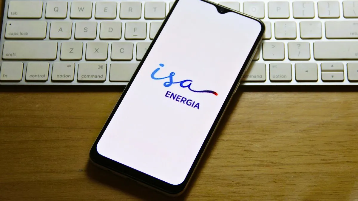 Smartphone com o logo da ISA Energia na tela, sobre um teclado, representando o balanço da empresa
