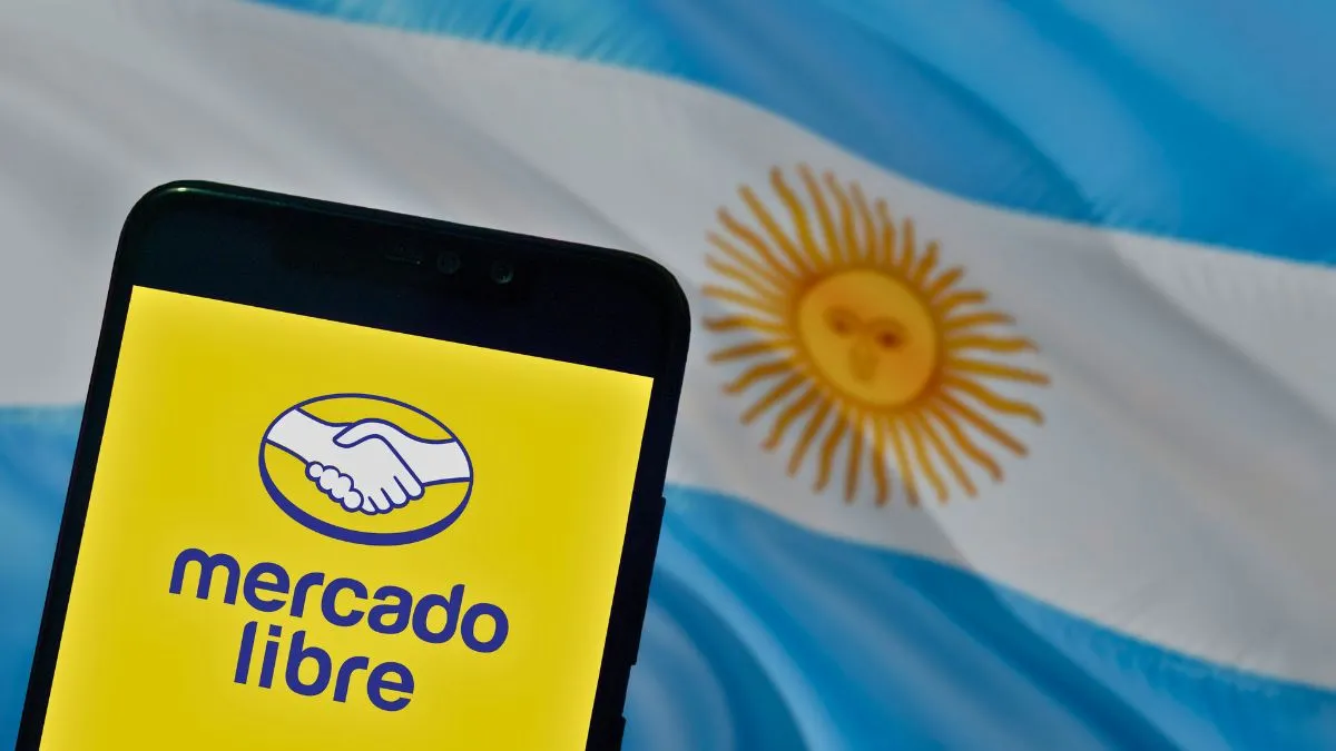 elefone com o aplicativo do Mercado Livre na tela, com a bandeira da Argentina ao fundo