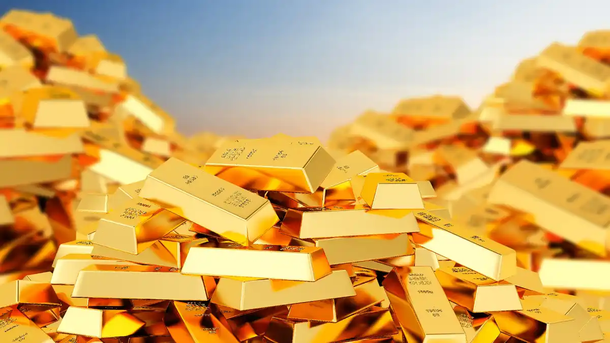 Grande pilha de barras de ouro (lingotes) brilhantes empilhadas em um cofre, simbolizando o novo ETF de ouro GOLB11.