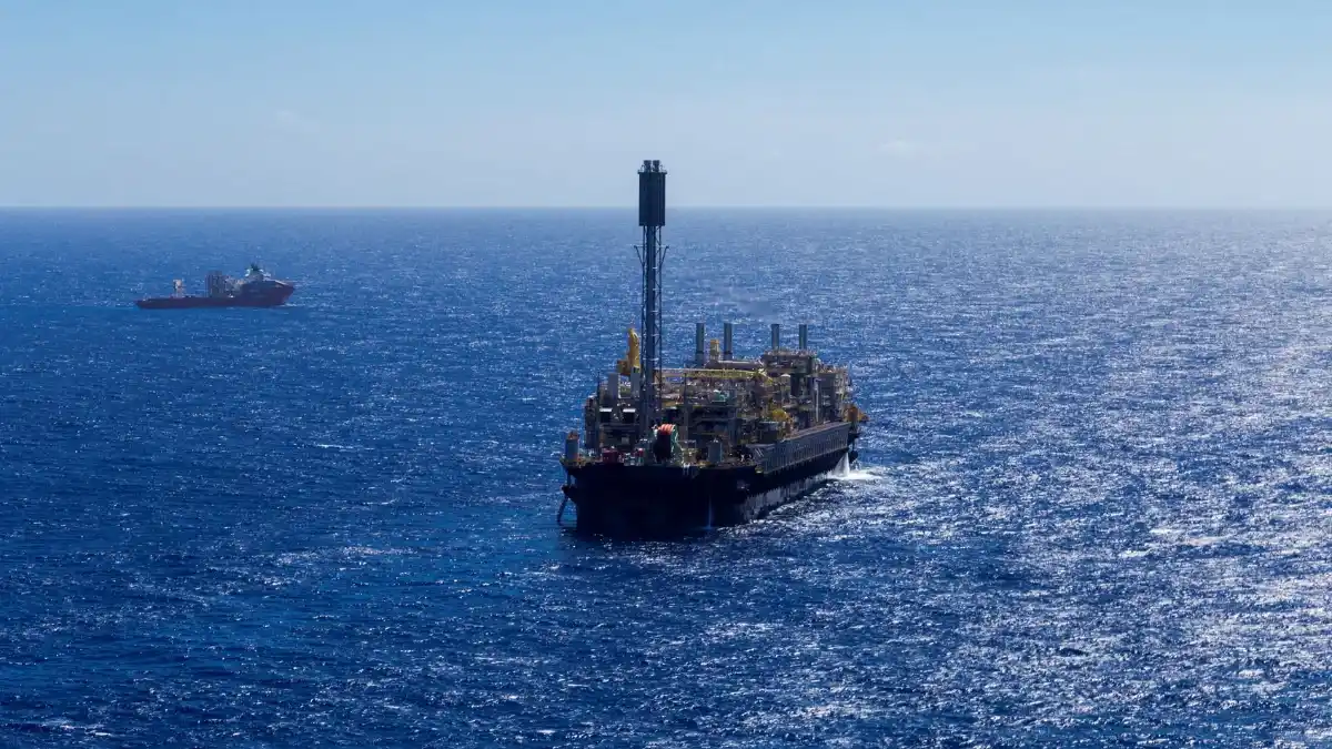 Texto alternativo (Alt Text): Plataforma de perfuração flutuante (drillship) no meio do oceano,