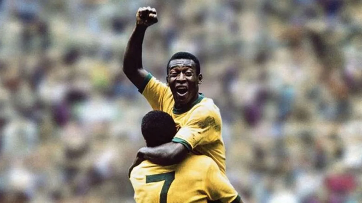 O ex-jogador Pelé (Rei do Futebol) celebrando um gol com os braços levantados em campo, simbolizando a compra de sua marca pelo pai de Neymar.